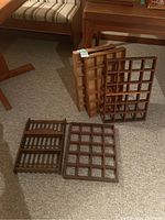 Photo showing 5 wooden display shelves with grid compartments laid on carpeted floor.