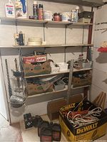 Utility room shelves with boxes, spray cans, tapes, wire basket, and chains.
