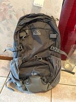 Front view of black Kolumb hiking backpack showing multiple compartments, adjustable side straps, and 26L label