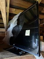 Photo of LG 42-inch LED TV with bubble wrap and remote on base stand and sticky note showing size and remote included.
