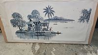 Full view of the Asian themed oil painting showing houses, palm tree, water and distant mountains.