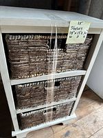 Front view showing 3 woven baskets fitted on shelves with a handwritten label displaying measurements.