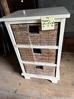 Front view of wooden shelving unit with three rectangular woven wicker drawers and a handwritten note showing dimensions.