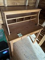 Front angled view showing upper storage compartments, drawer, and sturdy wood construction.