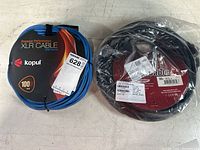 Blue 100ft Kopul XLR cable coiled with label and a black 50ft HDMI cable sealed in plastic packaging.