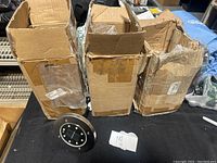 Three worn cardboard boxes containing LED solar path lights with one light displayed in front.