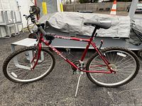 Full side view of red Fuji brand men's bicycle showing frame, tires, and saddle.