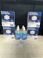 Four boxes of NIOSH N95 masks and four bottles of hand sanitizer arranged on a surface.