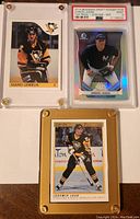 Front view of three cards: Mario Lemieux and Jaromir Jagr in screw-down acrylic cases, Aaron Judge in PSA slab