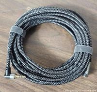 Black braided stereo audio extension cable coiled with visible 90 degree right angle 3.5mm male connector.