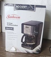 Box of Sunbeam 12 Cup Coffeemaker in Black Ice, showing features and brand.