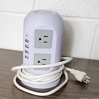 Front view of the vertical tower power strip showing two sides with rectangular two-outlet panels and 4 USB ports stacked vertically.