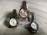 Three wristwatches displayed: Timex VIP Viewpoint in center with crystal markers and two additional quartz watches with expandable bracelets on each side.