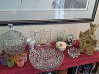 Overview of all assorted decor and drinkware items on table with red cloth