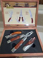 Photo of the 3 piece multi-tool set in the open wooden box with black foam insert, showing the tools and printed product info inside lid.
