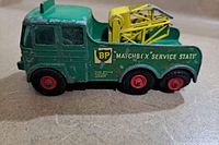 Side view of green metal toy vehicle showing BP branding and yellow crane.