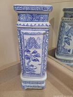 Front view of vase showing mountain and tree landscape art with floral patterns and geometric borders.