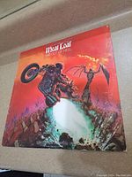 Front cover of Meat Loaf 'Bat Out Of Hell' vinyl album showing the iconic motorcycle rider artwork with fiery orange background.