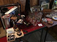 Photo showing wine glasses, openers, smaller items, and part of the wine rack