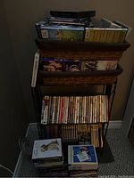 Metal shelving unit filled with DVDs and shows, some DVDs stacked on floor