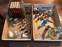 Two boxes of assorted small figurines including Wade, Jack Moxx, and Cabbage Patch Kids style figurines with various animals and decorative pieces.