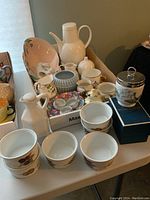 Photo showing collection of teapot, ramekins, cream and sugar sets, napkin rings, pink oval dish, and egg coddler box.