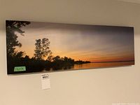 Front photo of rectangular scenic print showing sunset over water with trees, mounted on frame, labeled 12x36.