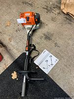 Overview of engine powerhead and instruction manual on concrete floor