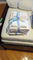 Two neatly folded white seersucker duvet cover sets wrapped with light blue ribbons.