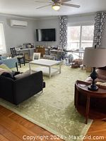 Living room view showing large green area rug under furniture