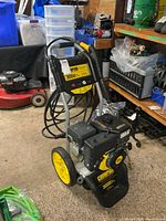Front and full view of Champion pressure washer on wheels with coiled hose and wand