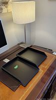 Faux leather filing trays on desk along with desk blotter and table lamp