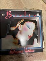 Photo of the Berlin Pleasure Victim vinyl album cover showing a stylized image of a woman's face in profile with album title and band name.