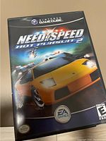 Front cover of Need for Speed Hot Pursuit 2 game case for Nintendo GameCube showing the game title and artwork featuring a yellow sports car and police chase scenes.