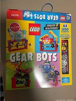 Photo of the LEGO Gear Bots original box showing front with colorful graphics, branding, and description of contents (62 LEGO elements to create 8 machines).