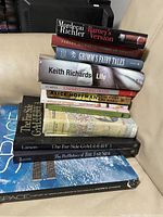 Stack of books with titles visible including Life by Keith Richards, Barney's Version, Grimm's Fairy Tales, and others.