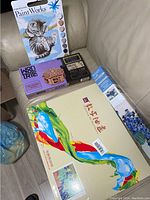 Photo showing Dimensions PaintWorks Paint By Number Kit (kitten), Wodtrik wooden puzzle box, large paint by number kit box, and blue floral decorative item.