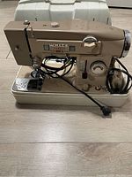Beige White 3210 sewing machine with power cord and metal body showing model number.