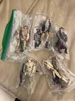 Five Star Wars action figures in plastic bags displayed on a surface
