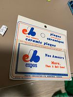 Photo of the vintage ceramic Montreal Expos plaque in original packaging showing logo and text