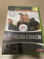 Photo of sealed Xbox game NFL Head Coach in original green game case with some perforations in the seal.