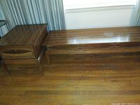 Photo showing two vintage wooden end tables and a long sofa table with drawers on wood floor, front view