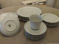 Photo showing stacks of various size plates and one cup from the Crown Victoria Love Lace Pattern 30-piece china set.