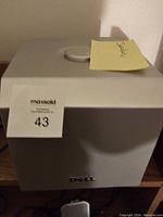 Front angled view of the gray Dell subwoofer speaker showing the Dell logo and control knob on top, with lot sticker 43 attached.