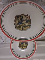 Photo showing an oval platter and a round bowl, both with an Italian-themed pasta chef design and red, green, white stripes around the edges.