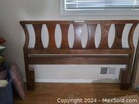 Queen wood headboard with curved vertical slats, brown finish, with some scratches visible on surface, no frame included