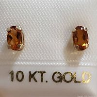 Close-up image showing the yellow gold setting and orange faceted citrine gemstones with '10 KT. GOLD' marking.