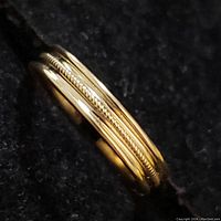 Close-up of the 10K yellow gold toe ring showing polished surface and rope-like center detail.