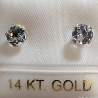 Close-up of white topaz gemstone stud earring set in 14K white gold with prong setting.