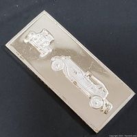 Oblique front view showing two classic car embossments on the sterling silver bar surface.